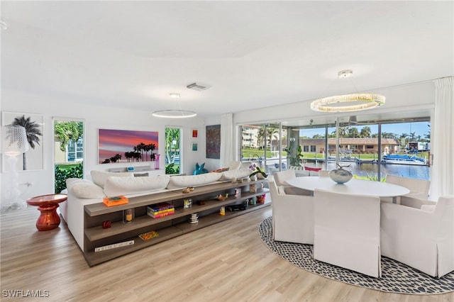 dining room featuring light hardwood / wood-style flooring and a water view