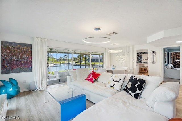 living room with light wood-type flooring and a water view