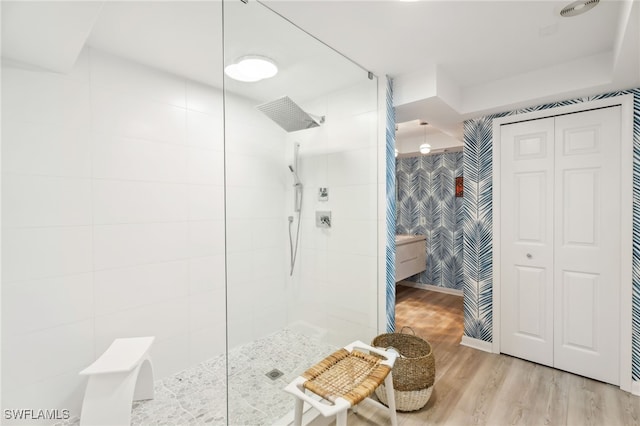 bathroom with hardwood / wood-style flooring and tiled shower