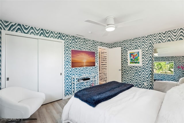 bedroom featuring ceiling fan, a closet, and light wood-type flooring