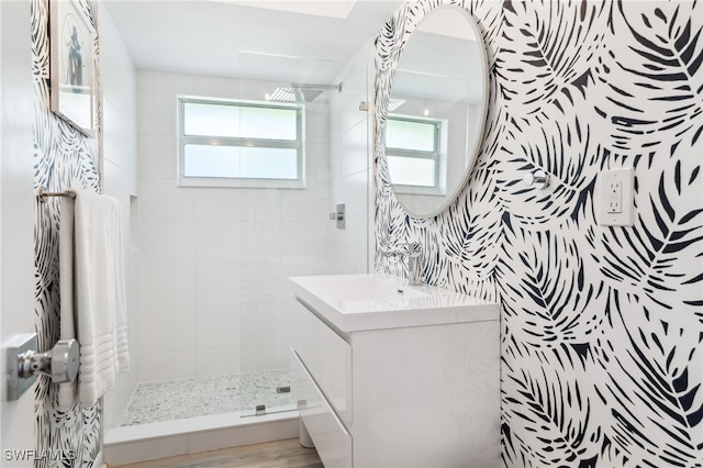 bathroom featuring vanity, wood-type flooring, and a tile shower