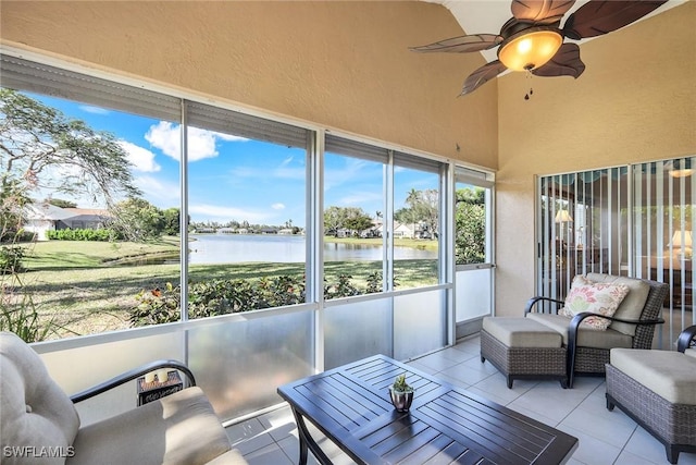 sunroom featuring a water view and ceiling fan