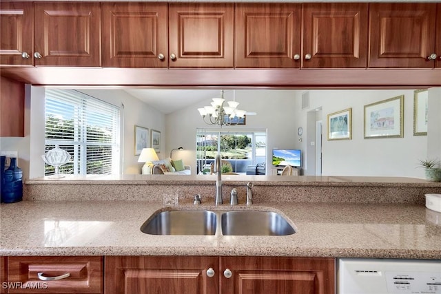 kitchen with lofted ceiling, sink, a chandelier, white dishwasher, and light stone countertops