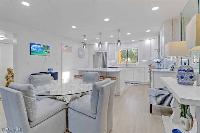 dining area featuring sink and light hardwood / wood-style floors