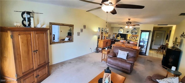 living room with lofted ceiling, ceiling fan, visible vents, and light colored carpet