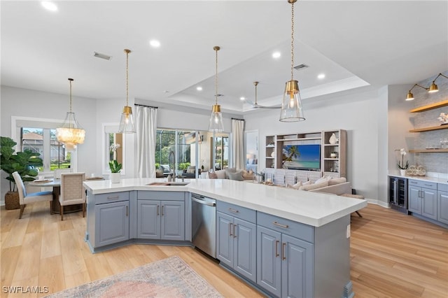 kitchen with wine cooler, sink, light hardwood / wood-style flooring, stainless steel dishwasher, and a tray ceiling