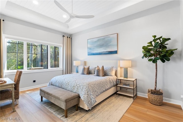 bedroom with wood-type flooring, wooden ceiling, a raised ceiling, and ceiling fan