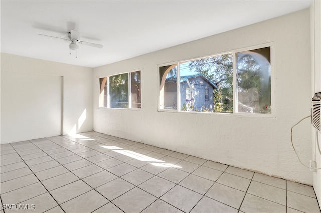 tiled empty room featuring ceiling fan