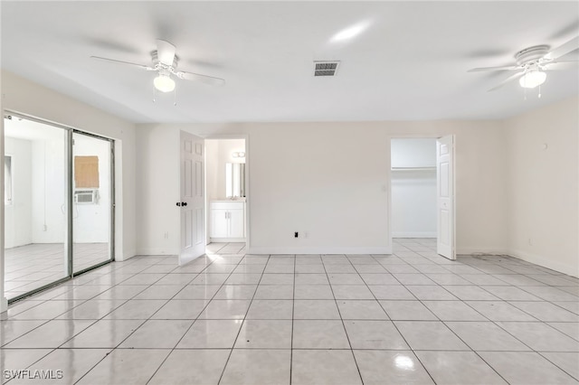 tiled empty room featuring ceiling fan