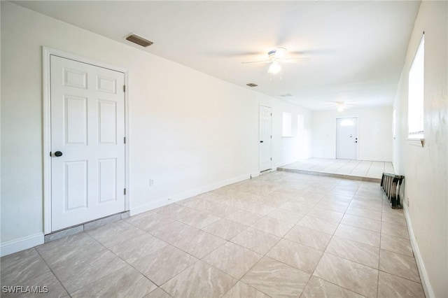 tiled spare room with plenty of natural light and ceiling fan