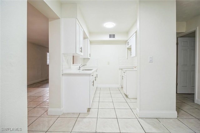 kitchen featuring white cabinetry, light tile patterned flooring, sink, and decorative backsplash