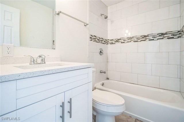 full bathroom featuring tiled shower / bath, vanity, and toilet