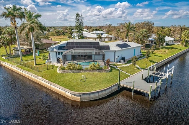 back of house featuring a lanai, a lawn, and a water view