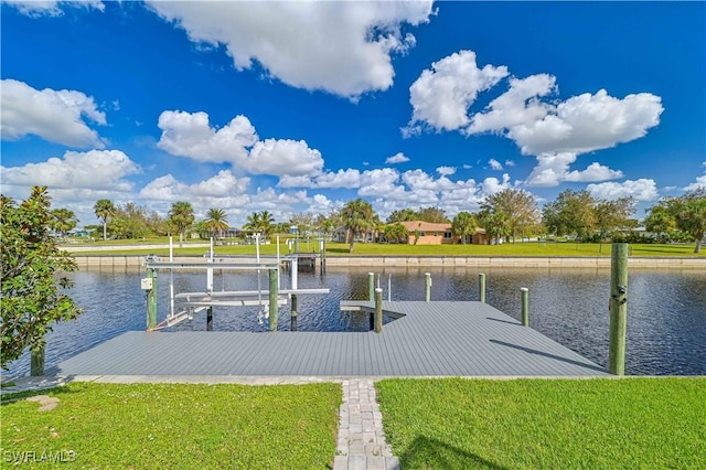 dock area with a water view and a yard