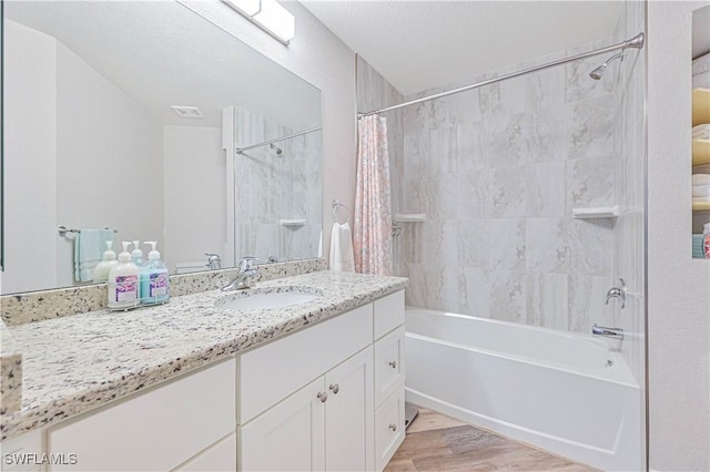 bathroom featuring wood-type flooring, shower / tub combo with curtain, and vanity