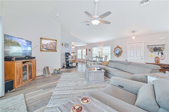 living room with ceiling fan, high vaulted ceiling, and light hardwood / wood-style flooring