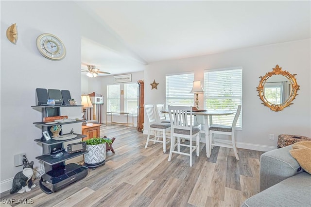 dining room featuring ceiling fan, lofted ceiling, and light hardwood / wood-style flooring