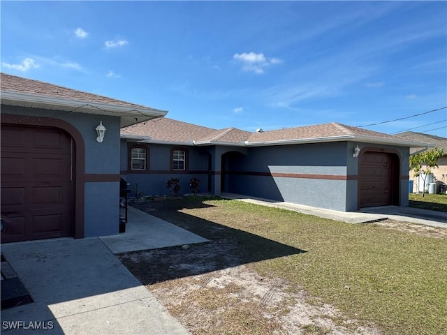 ranch-style house with a garage and a front lawn