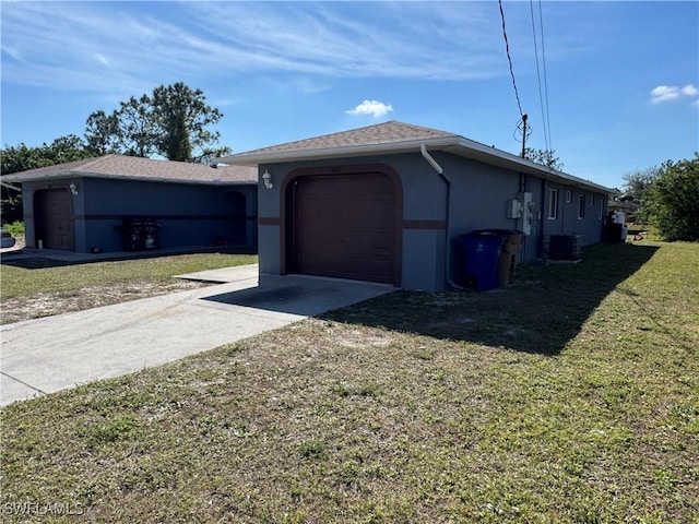 view of side of property featuring a garage, a lawn, and central air condition unit