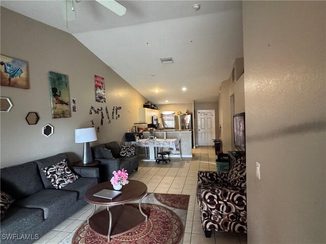 living room featuring ceiling fan, light tile patterned flooring, and vaulted ceiling