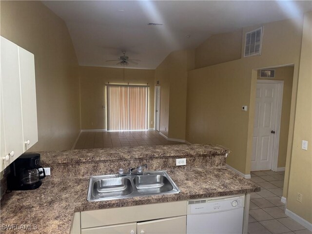 kitchen with vaulted ceiling, sink, light tile patterned flooring, dishwasher, and white cabinets