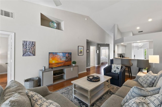 living room featuring wood-type flooring and high vaulted ceiling