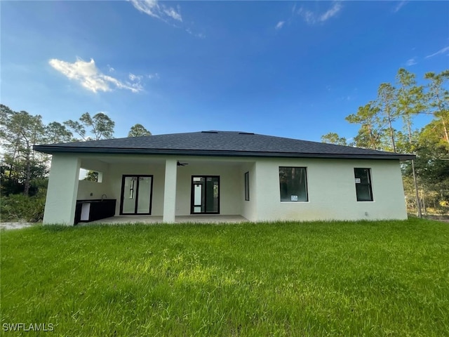 back of house with a patio and a yard