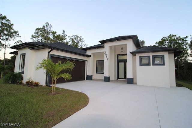 prairie-style house with a garage and a front yard