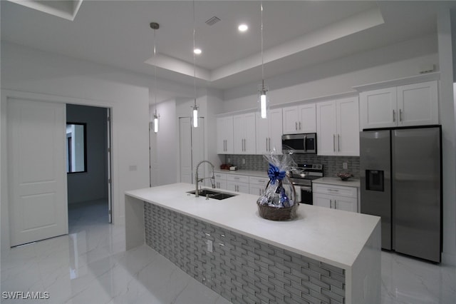 kitchen with stainless steel appliances, sink, white cabinets, and a tray ceiling