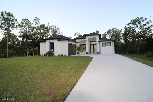 prairie-style house with a garage and a front lawn