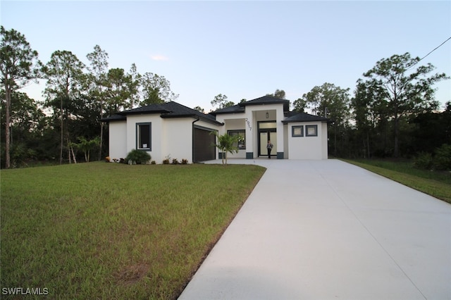 prairie-style home with a garage and a front lawn