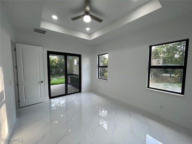 unfurnished room with a raised ceiling and ceiling fan