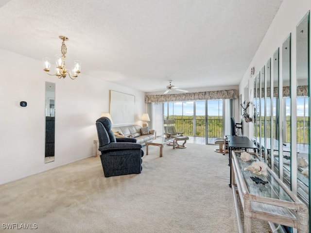 carpeted living room with ceiling fan with notable chandelier