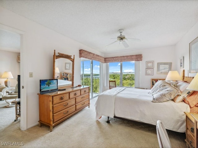 carpeted bedroom with a textured ceiling, access to outside, and ceiling fan