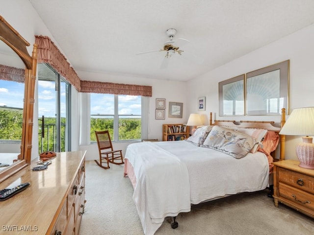 bedroom with light carpet, access to exterior, and ceiling fan