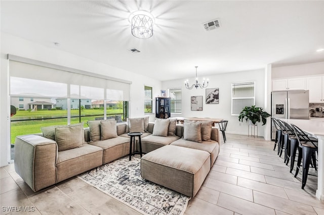 tiled living room featuring a notable chandelier