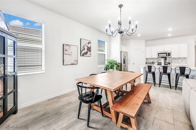 dining area with an inviting chandelier and light hardwood / wood-style flooring