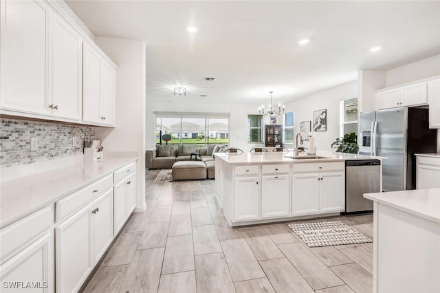 kitchen featuring white cabinetry, sink, pendant lighting, and appliances with stainless steel finishes