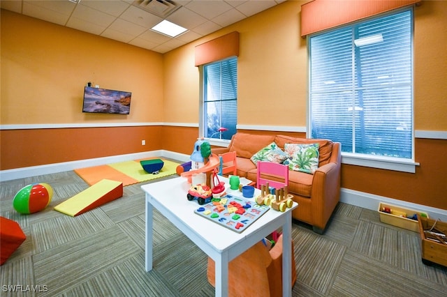 rec room featuring carpet and a paneled ceiling