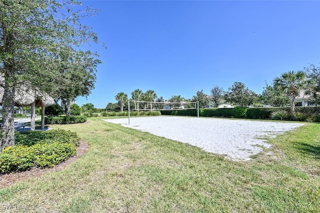 view of property's community featuring a lawn and volleyball court