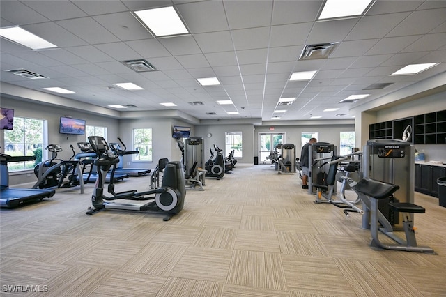 workout area featuring a paneled ceiling and light carpet