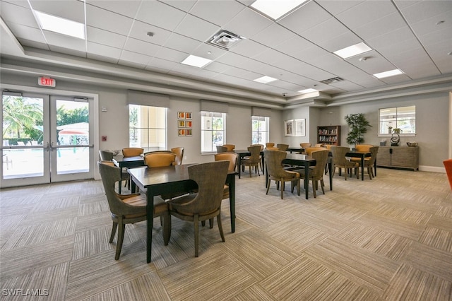 dining space with plenty of natural light, light carpet, and french doors