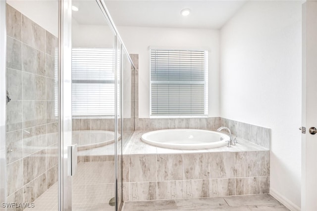 bathroom featuring independent shower and bath