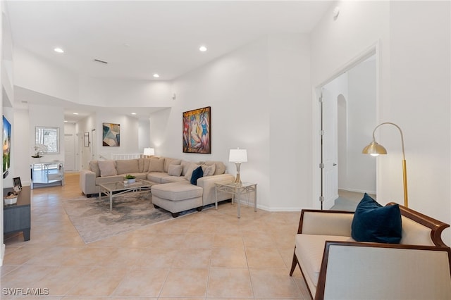 living room featuring a towering ceiling and light tile patterned floors