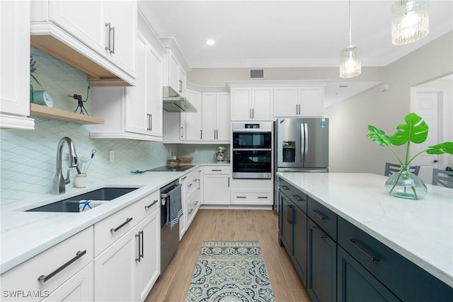 kitchen with appliances with stainless steel finishes, sink, hanging light fixtures, and white cabinets