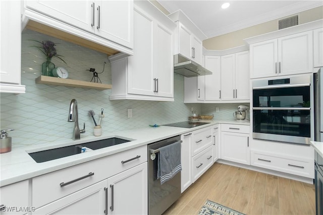 kitchen with sink, stainless steel appliances, tasteful backsplash, ornamental molding, and white cabinets