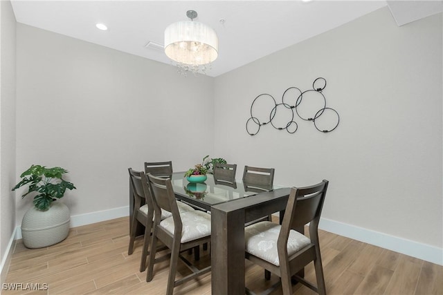 dining space featuring an inviting chandelier and light wood-type flooring