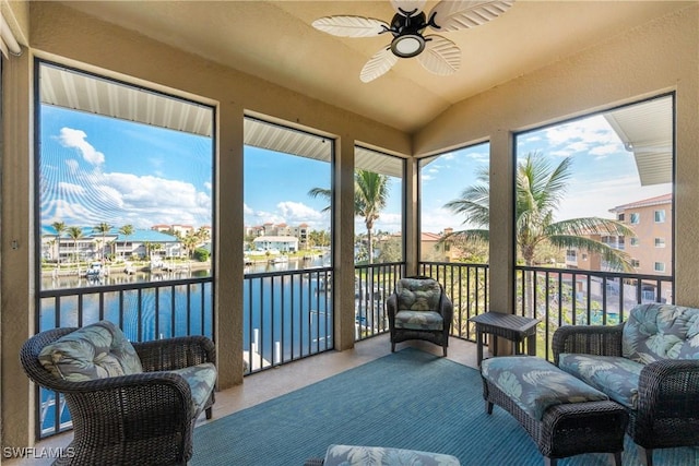 sunroom featuring a water view, lofted ceiling, and ceiling fan