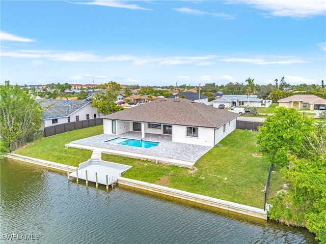 back of property featuring a water view, a yard, and a patio area