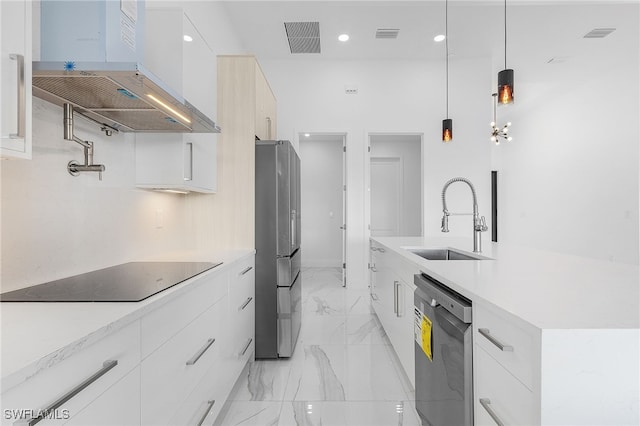 kitchen featuring sink, extractor fan, pendant lighting, stainless steel appliances, and white cabinets